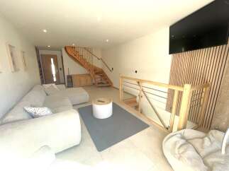 Step into this modern living space featuring a comfortable sectional sofa and a stylish round coffee table.