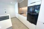 Discover this modern kitchen featuring sleek white cabinetry and warm wood accents.