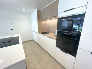 Discover this modern kitchen featuring sleek white cabinetry and warm wood accents.