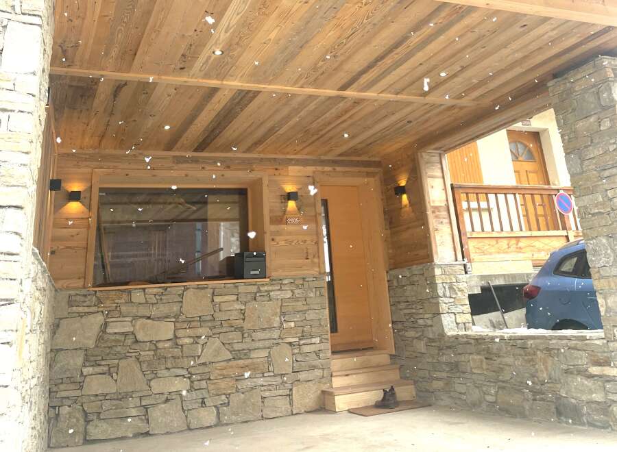 Experience rustic charm and modern comfort in this mountain retreat, featuring a natural stone facade and a warm wooden interior.