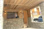 Experience rustic charm and modern comfort in this mountain retreat, featuring a natural stone facade and a warm wooden interior.
