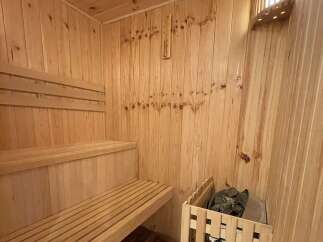 Experience ultimate relaxation in this beautifully crafted wooden sauna, featuring comfortable tiered seating perfect for unwinding.