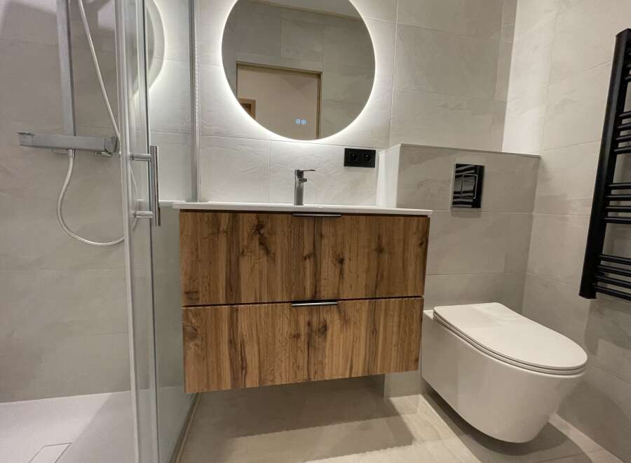 Experience modern luxury in this stunning bathroom featuring a sleek vanity with ample storage and a floating design.