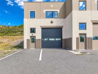 This modern commercial building features a striking facade with contrasting beige and cream tones, accented by diamond-shaped details and multiple windows.