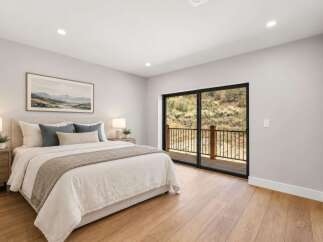 Experience serene living in this beautifully appointed bedroom, featuring a plush king-sized bed and a large framed landscape artwork.
