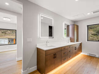 Experience modern luxury in this stunning bathroom featuring a double vanity with sleek cabinetry and integrated LED lighting.