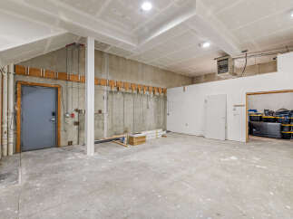Discover this versatile unfinished space, perfect for a workshop, storage, or customization.