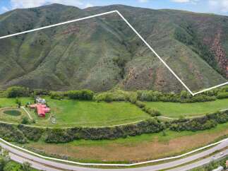 Discover this expansive property nestled against a majestic mountain backdrop, offering unparalleled privacy and breathtaking natural beauty.
