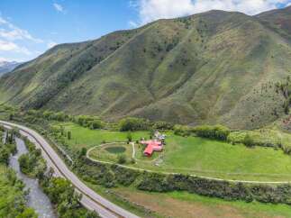 Experience luxury living in this stunning estate nestled against a majestic mountain backdrop.