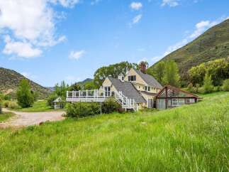Nestled against a majestic mountain backdrop, this charming yellow home offers a serene retreat.
