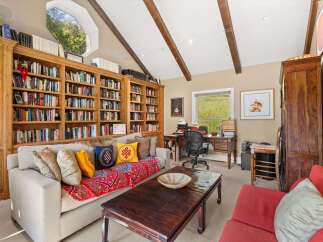 This inviting home office features a wall of built-in bookshelves, perfect for organizing your extensive library.