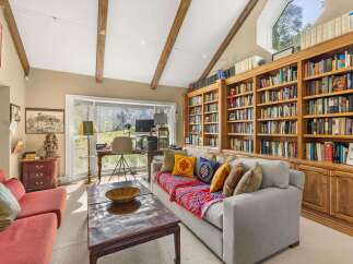 Discover a cozy reading nook with a large, built-in bookshelf filled with a diverse collection of books.