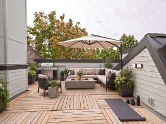 Experience luxurious outdoor living on this stunning rooftop deck, complete with a built-in grill, comfortable sectional sofa, and a modern fire pit.