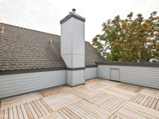 Experience outdoor living at its finest on this expansive rooftop deck, featuring a unique wood-slat flooring pattern that adds a modern touch.
