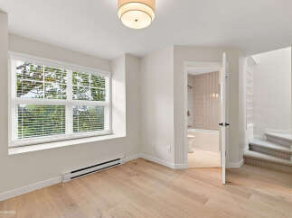 Discover modern living in this bright and airy space featuring a large window with blinds, offering ample natural light and scenic views.