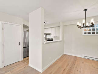 Discover modern living in this beautifully renovated space, featuring a sleek, open-concept kitchen with stainless steel appliances and ample cabinet storage.