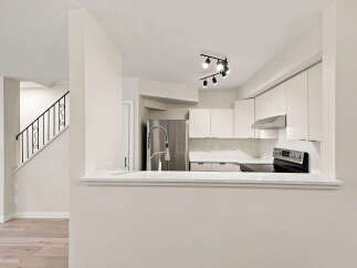 Discover this beautifully renovated kitchen featuring sleek white cabinetry and modern stainless steel appliances.