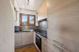 Discover this charming kitchen featuring modern light wood cabinetry and sleek black countertops.