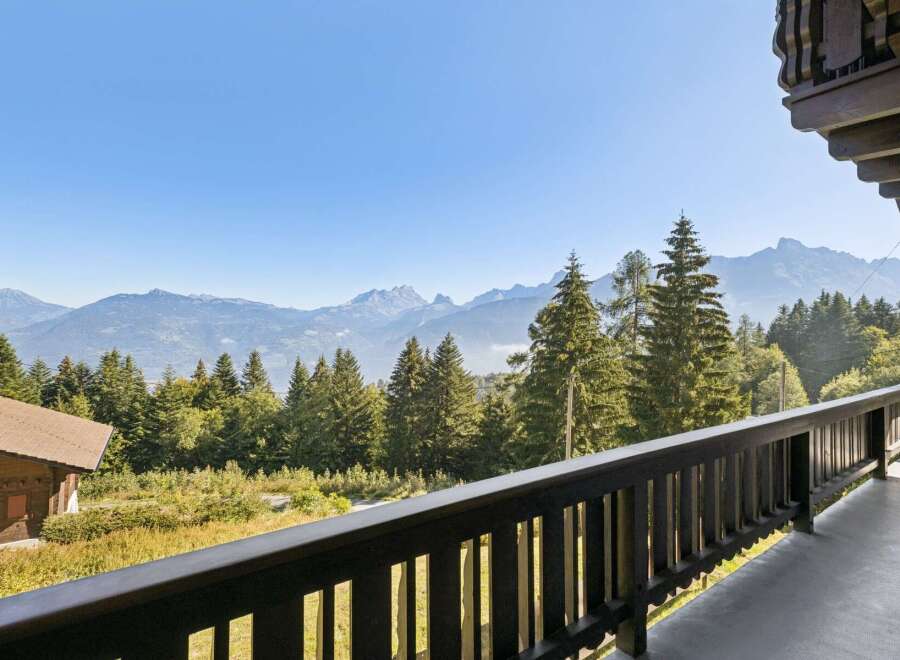 Experience breathtaking mountain views from this charming property, nestled amidst lush greenery and towering pine trees.