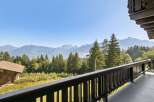 Experience breathtaking mountain views from this charming property, nestled amidst lush greenery and towering pine trees.