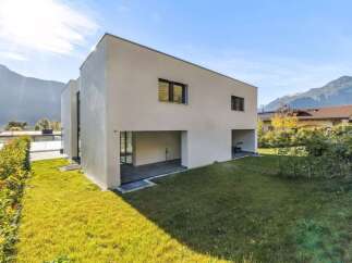 Discover modern living in this stunning contemporary home, featuring a sleek white facade and expansive green lawn.