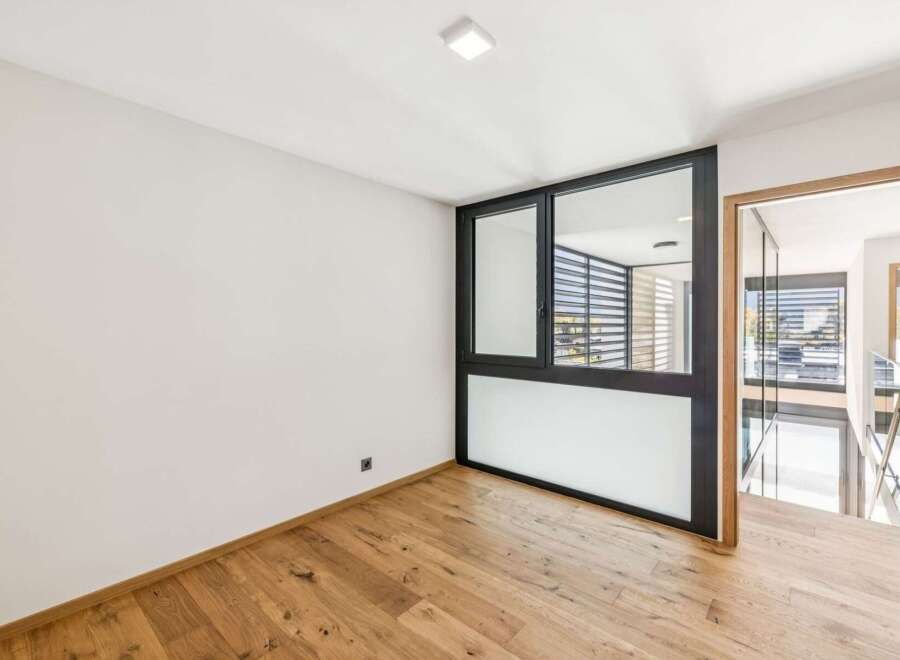 Experience modern living in this bright and airy space featuring sleek black-framed windows that offer abundant natural light.