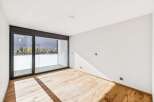 Experience modern living in this bright and airy room featuring a spacious balcony accessible through large sliding glass doors.