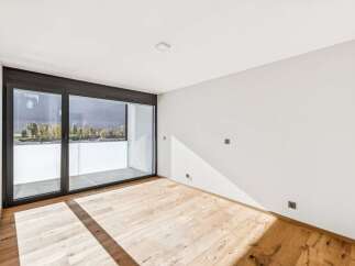 Experience modern living in this bright and airy room featuring a spacious balcony accessible through large sliding glass doors.