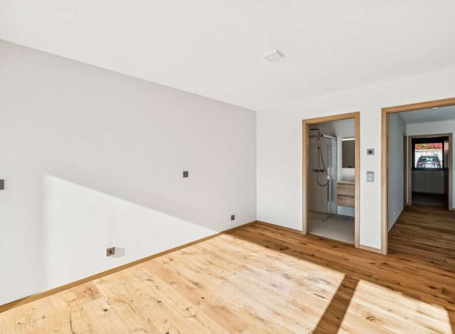 Experience modern living in this beautifully appointed room featuring a sleek en-suite bathroom with a glass-enclosed shower.