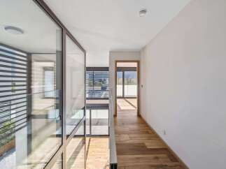 Experience modern living in this stunning home featuring expansive glass walls that flood the interior with natural light.