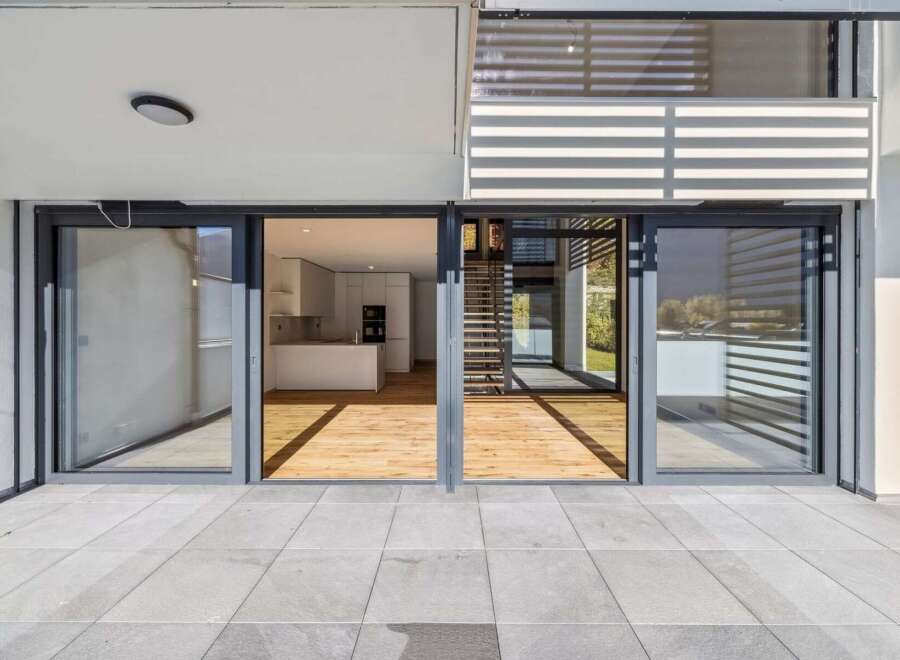 Experience modern living with this stunning property featuring expansive sliding glass doors that open onto a spacious patio.