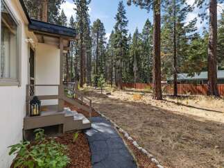 Discover this charming home nestled amongst tall pine trees, offering a serene and private setting.
