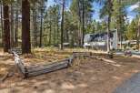 Nestled amidst tall pine trees, this charming property offers a serene retreat with a rustic split-rail fence bordering the grounds.