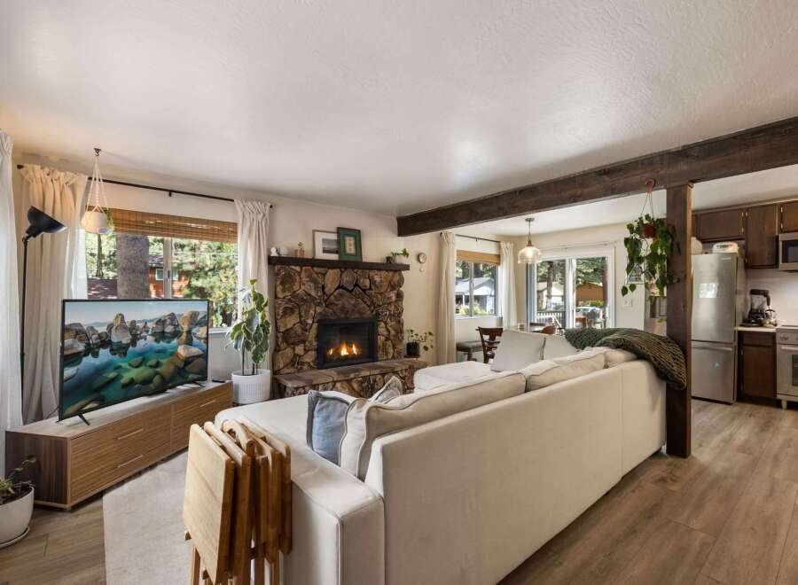 Cozy living room featuring a rustic stone fireplace and a large sectional sofa, perfect for relaxing evenings.