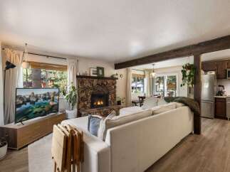 Cozy living room featuring a rustic stone fireplace and a large sectional sofa, perfect for relaxing evenings.
