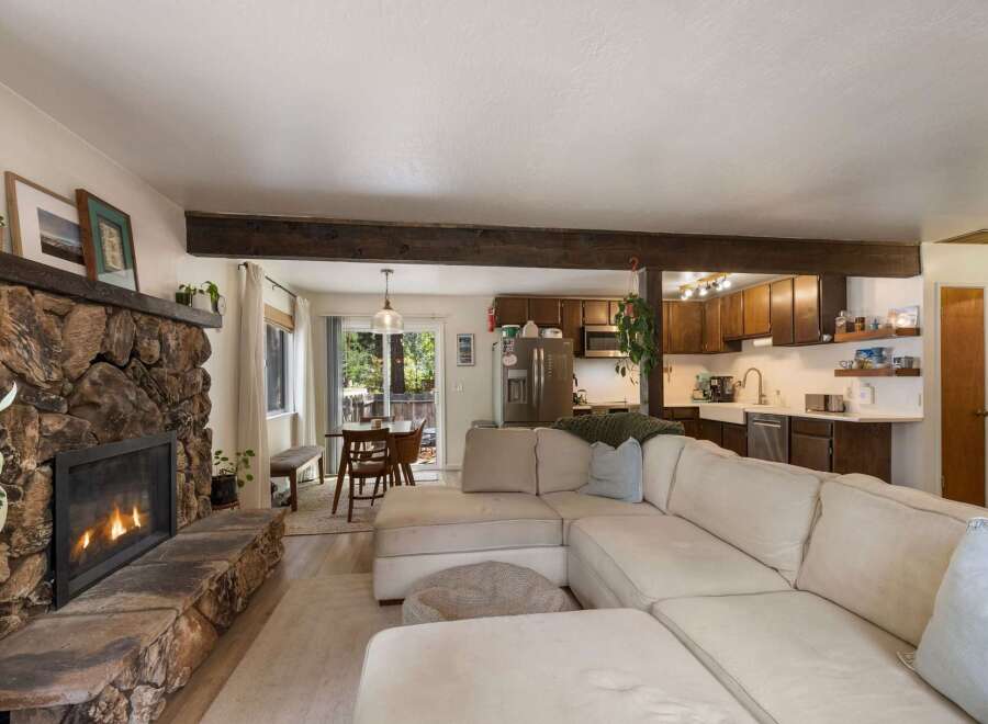 Cozy living room featuring a large stone fireplace and a comfortable sectional sofa, perfect for relaxing evenings.