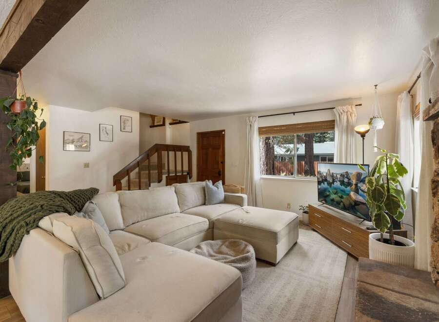 Step into this inviting living room, featuring a plush sectional sofa perfect for relaxation and a large TV for entertainment.