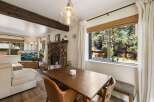 Cozy living room featuring a stone fireplace and a large window with scenic forest views.