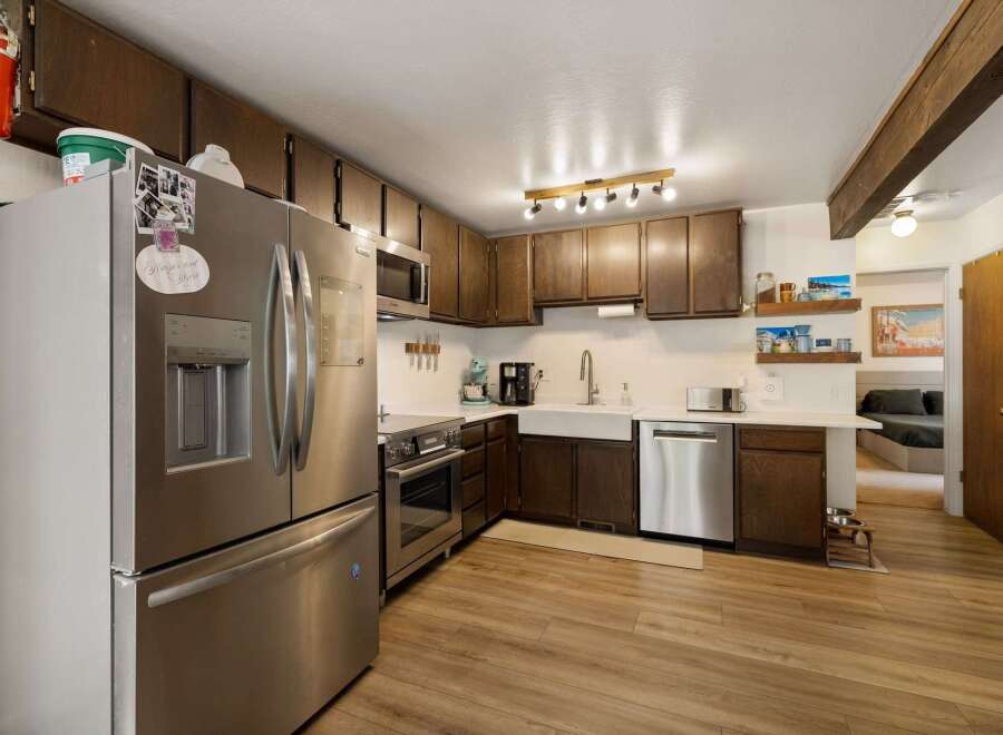 Discover this charming kitchen featuring stainless steel appliances, including a French door refrigerator and a built-in microwave.