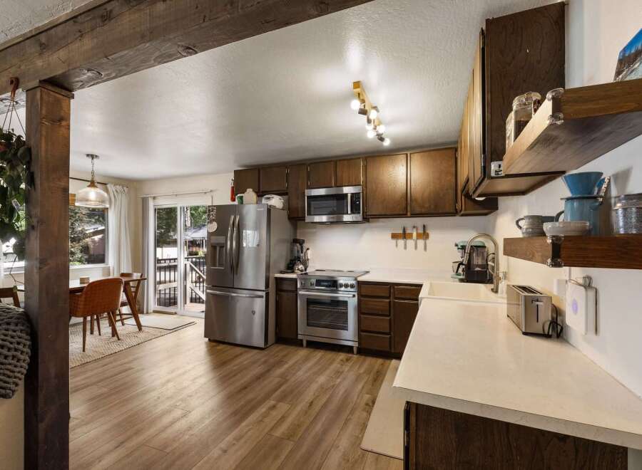 Discover this charming kitchen featuring rich wood cabinetry, a sleek stainless steel refrigerator, and a modern microwave.