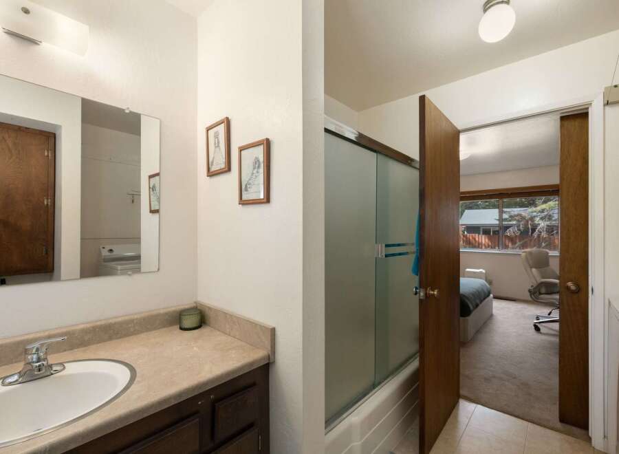 This bathroom features a spacious vanity with ample counter space and a large mirror, perfect for your morning routine.