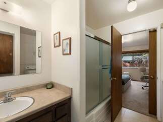 This bathroom features a spacious vanity with ample counter space and a large mirror, perfect for your morning routine.