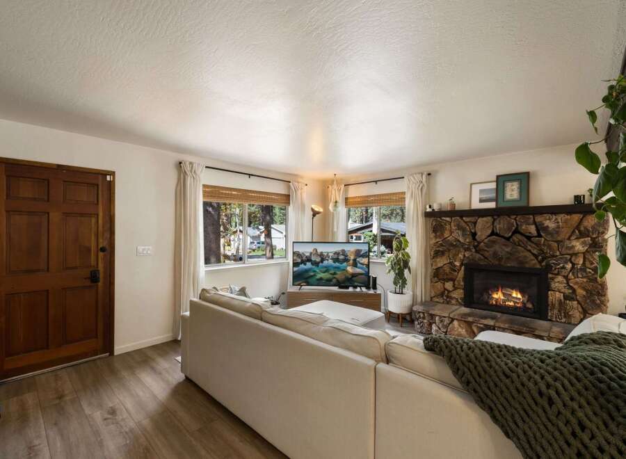 Cozy living room featuring a large stone fireplace with a roaring fire, perfect for chilly evenings.