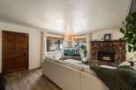 Cozy living room featuring a large stone fireplace with a roaring fire, perfect for chilly evenings.