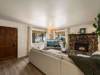 Cozy living room featuring a large stone fireplace with a roaring fire, perfect for chilly evenings.