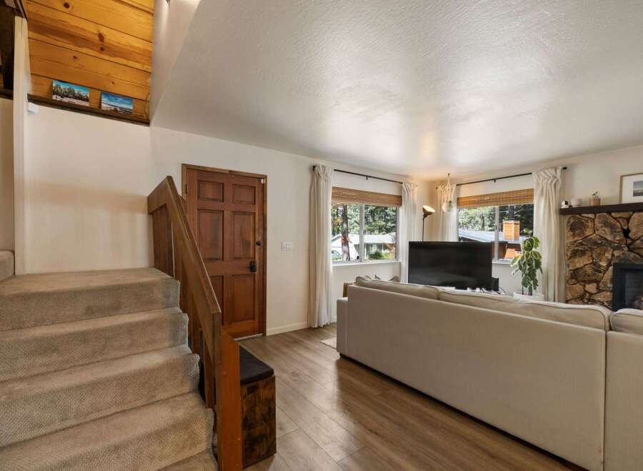 Step into this inviting living space featuring a cozy stone fireplace and a large sectional sofa perfect for gatherings.