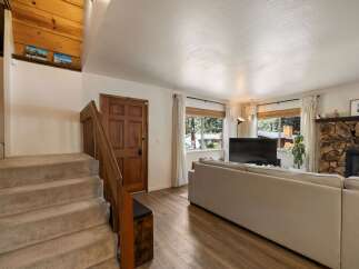 Step into this inviting living space featuring a cozy stone fireplace and a large sectional sofa perfect for gatherings.