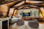 Experience cozy living in this charming attic room, featuring a comfortable daybed, plush beanbag chairs, and a large flat-screen TV for entertainment.