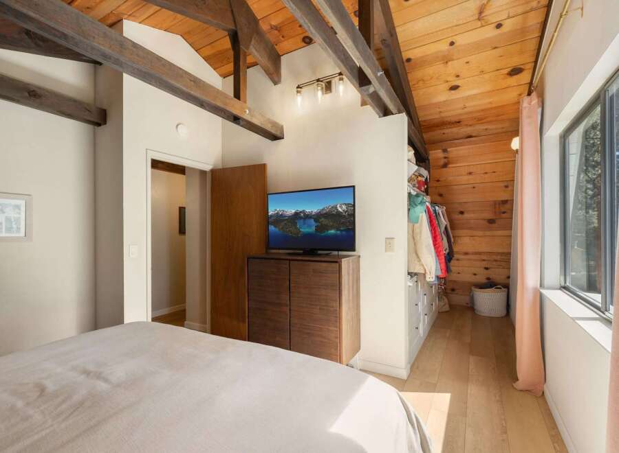 Experience rustic charm in this bedroom featuring exposed wooden beams and a vaulted ceiling.