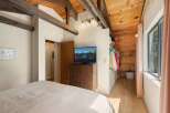 Experience rustic charm in this bedroom featuring exposed wooden beams and a vaulted ceiling.